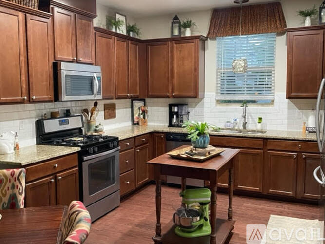 A kitchen with wooden cabinets and a green stool.