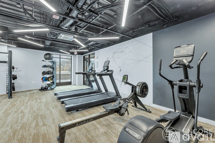 A gym with treadmills, elliptical machines, and other exercise equipment.
