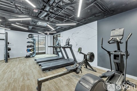 A gym with treadmills, elliptical machines, and other exercise equipment.