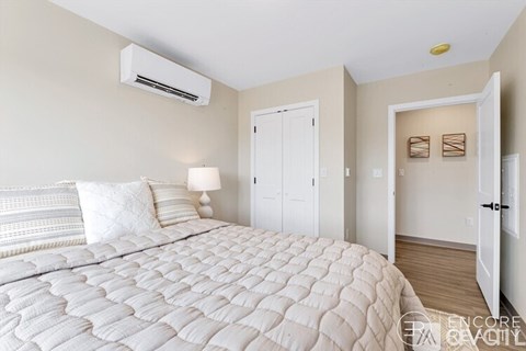 A bedroom with a large bed and a white ceiling fan.