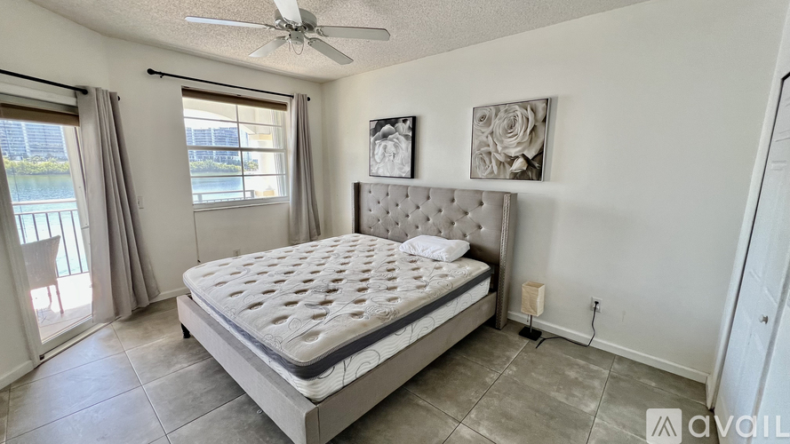 A bedroom with a large bed and a ceiling fan.