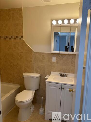 A bathroom with a toilet, sink, and bathtub.