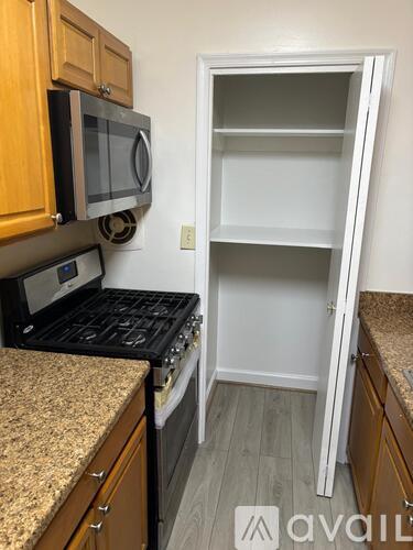 A kitchen with a granite countertop and a microwave above it.