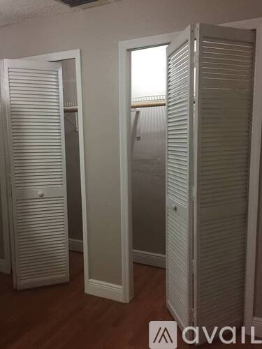 Closet doors in a room with wooden floors.