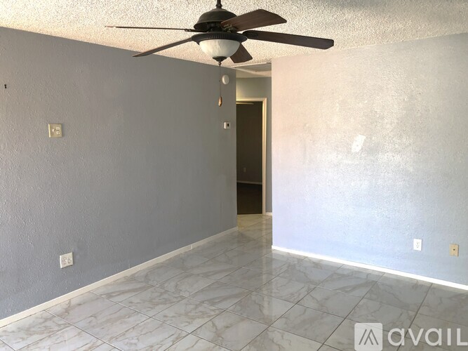 A room with a ceiling fan and a door.