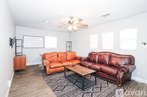 A living room with a brown leather couch and a wooden coffee table.
