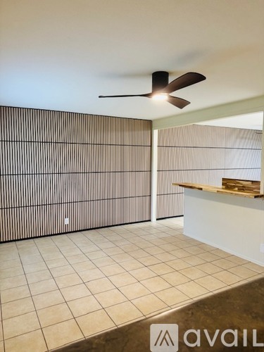 A room with a ceiling fan and a counter.