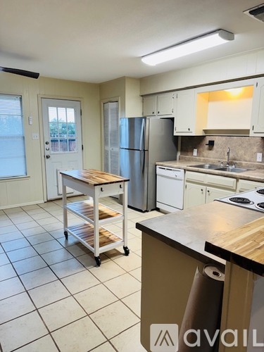 A kitchen with a refrigerator, oven, and sink.