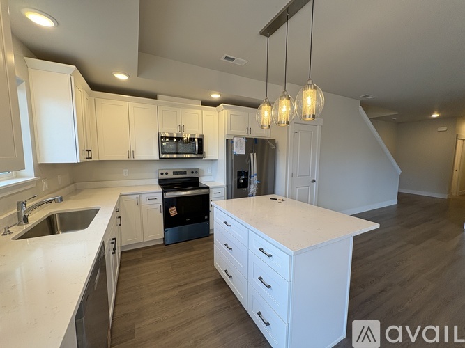A kitchen with white cabinets and a large island.