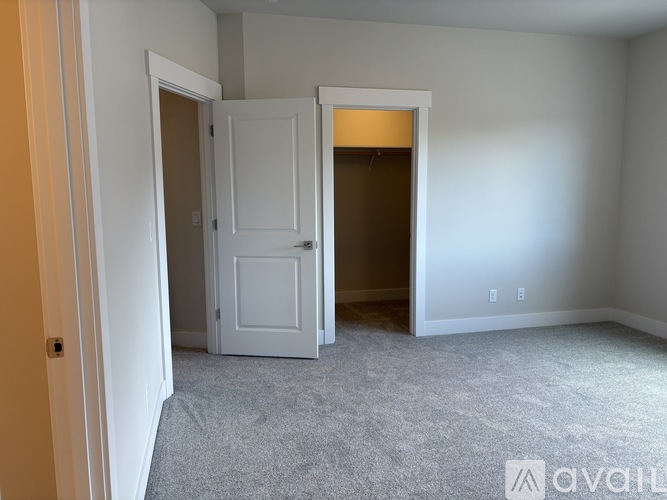 A room with a white door and a carpeted floor.