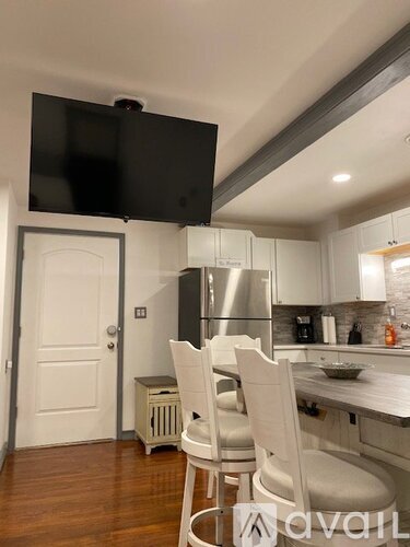 A kitchen with a table and chairs and a television mounted above it.
