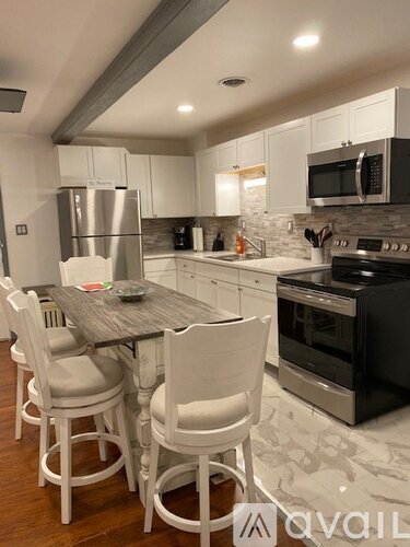 A kitchen with a table and chairs.