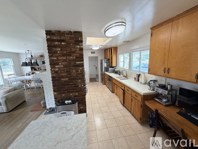 A kitchen with wooden cabinets and a brick wall.