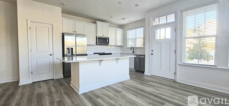 A kitchen with white cabinets and a white island with a countertop.