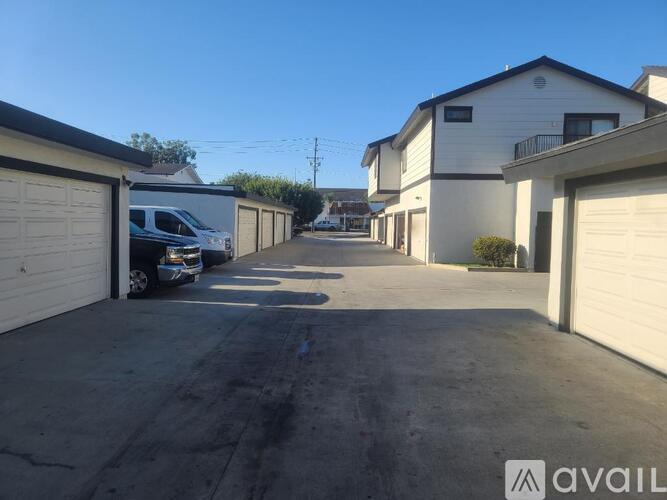 A row of garages with cars parked in them.