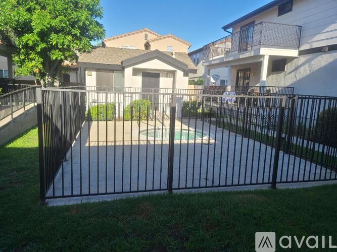 A black metal fence surrounds a green lawn.