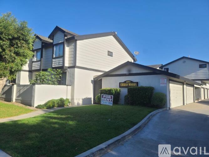 A house with a sign that says "Urban Woods" is for sale.
