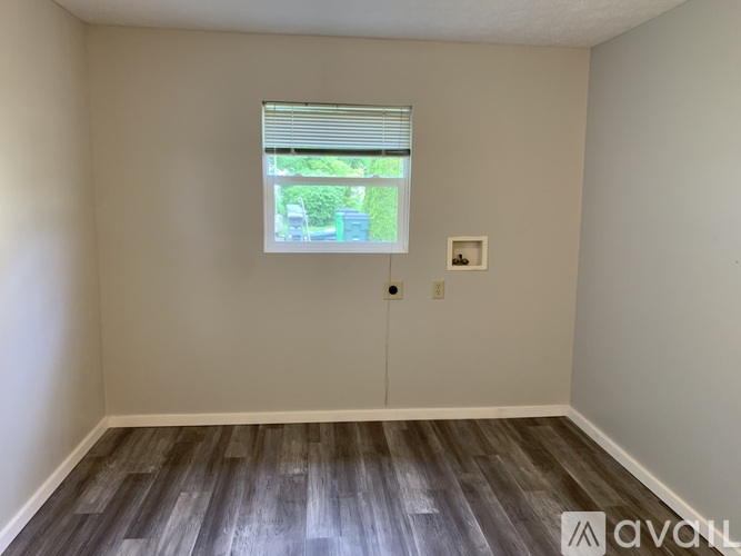A room with a window and wooden flooring.