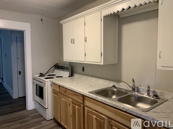 A kitchen with a white stove, wooden cabinets, and a marble countertop.