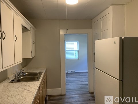 A kitchen with white cabinets and a white fridge.