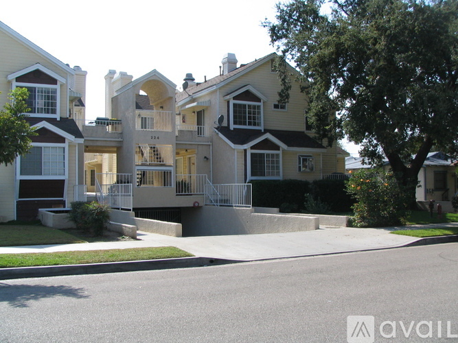 A large, multi-story house with a driveway in front.