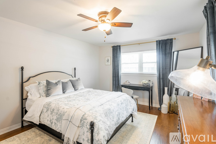 A bedroom with a large bed and a ceiling fan.