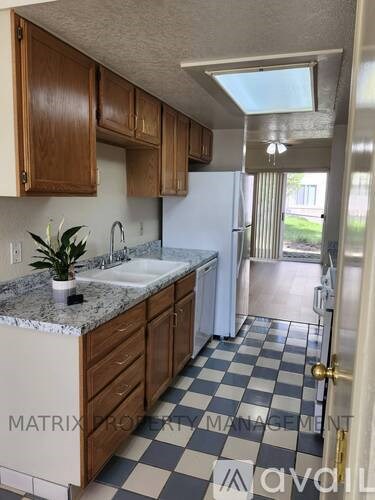 A kitchen with a checkered floor and a white fridge.