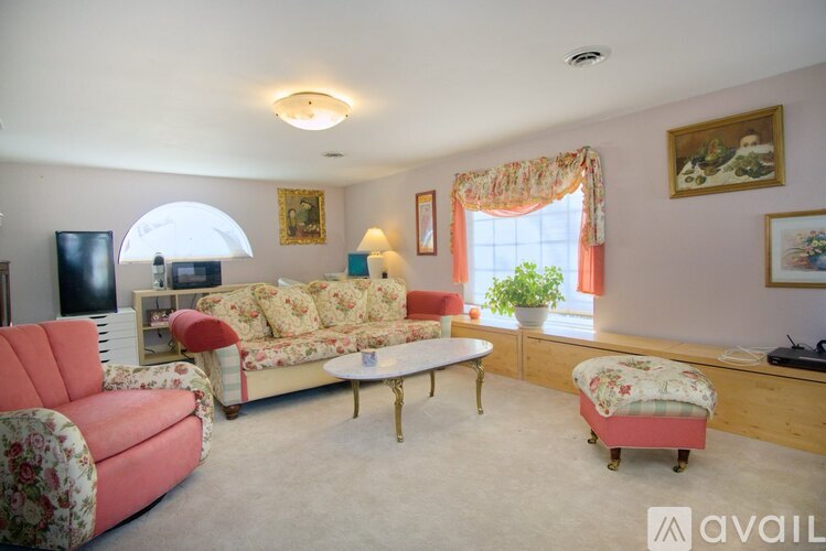 A living room with a red couch and a white coffee table.