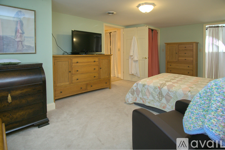 A bedroom with a bed, dresser, and wardrobe.