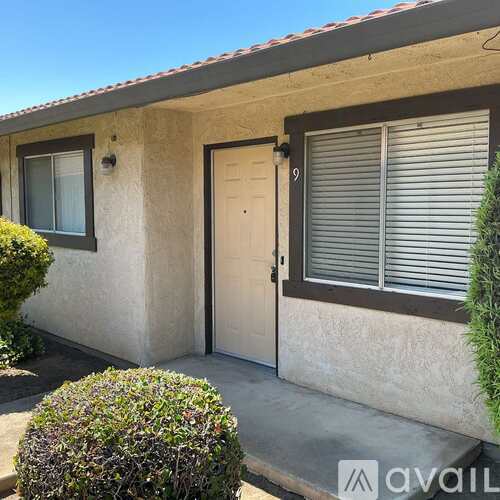 A house with a brown door and a window with blinds.