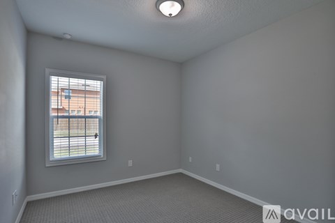 A room with a window and a view of a building outside.
