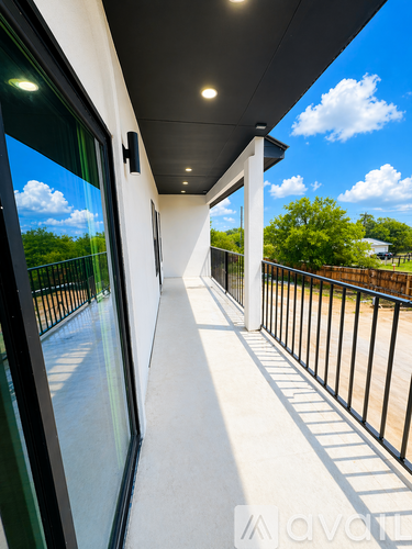 A long, narrow balcony with a view of the sky and trees.