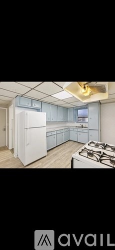 A kitchen with a white refrigerator and a stove top oven.