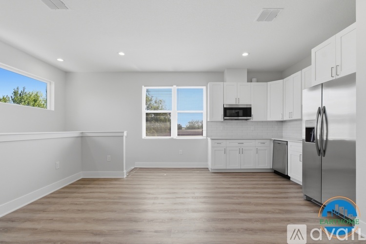 A kitchen with white cabinets and a wooden floor.