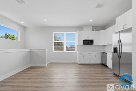 A kitchen with white cabinets and a wooden floor.