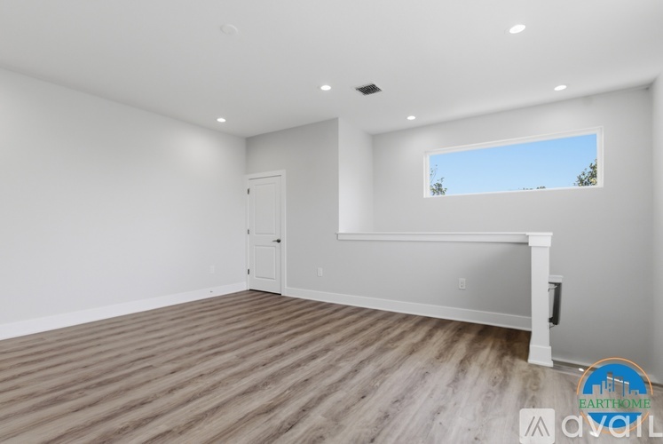A spacious room with a wooden floor and a window.