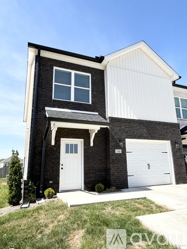 A two-story house with a white garage door and a black door.