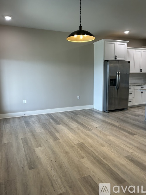 A kitchen with a refrigerator and cabinets in the background.
