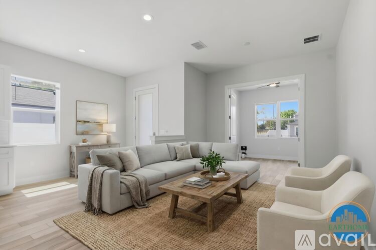 A living room with a grey sofa, a wooden coffee table, and a rug on the floor.