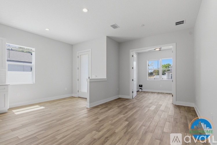 A spacious room with wooden flooring and white walls.