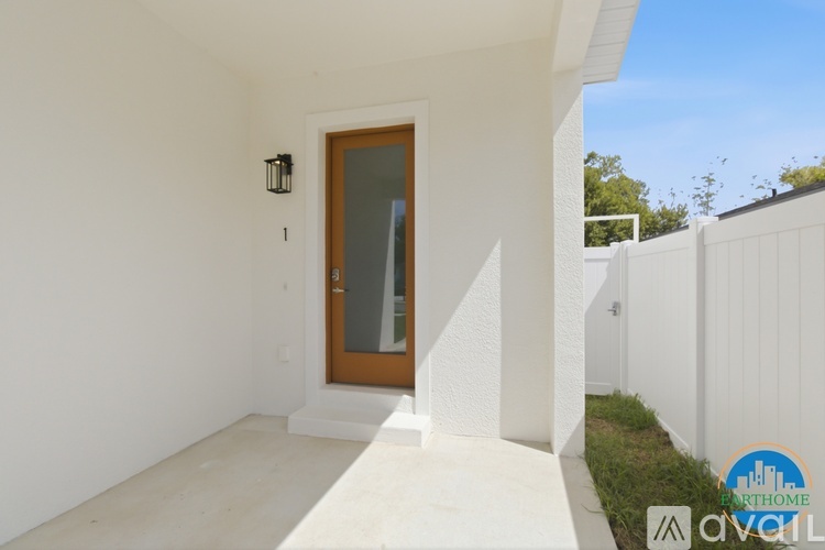 A modern house entrance with a glass door and a white wall.