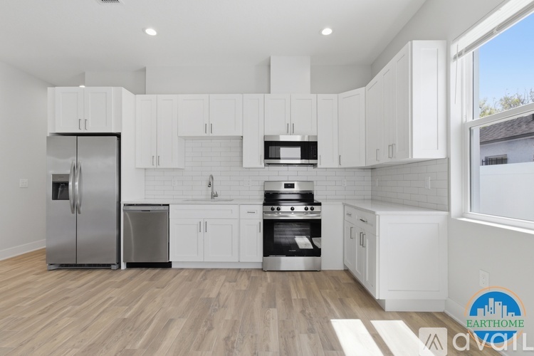 A kitchen with white cabinets and a refrigerator.