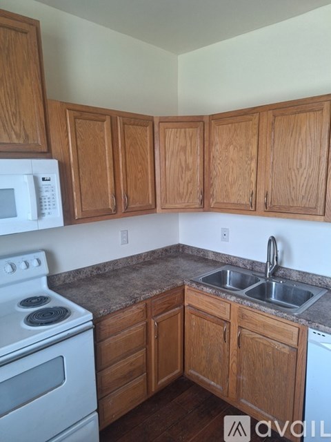 A kitchen with wooden cabinets and a white stove.