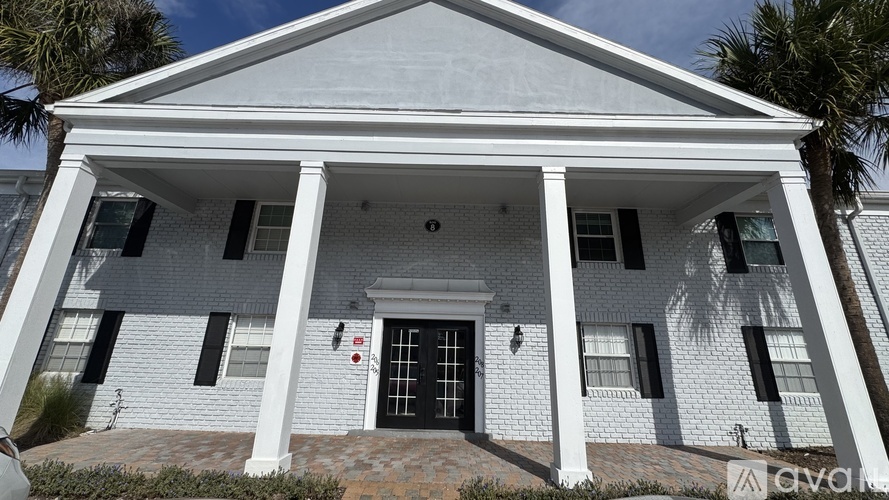 A white house with a black front door and windows.