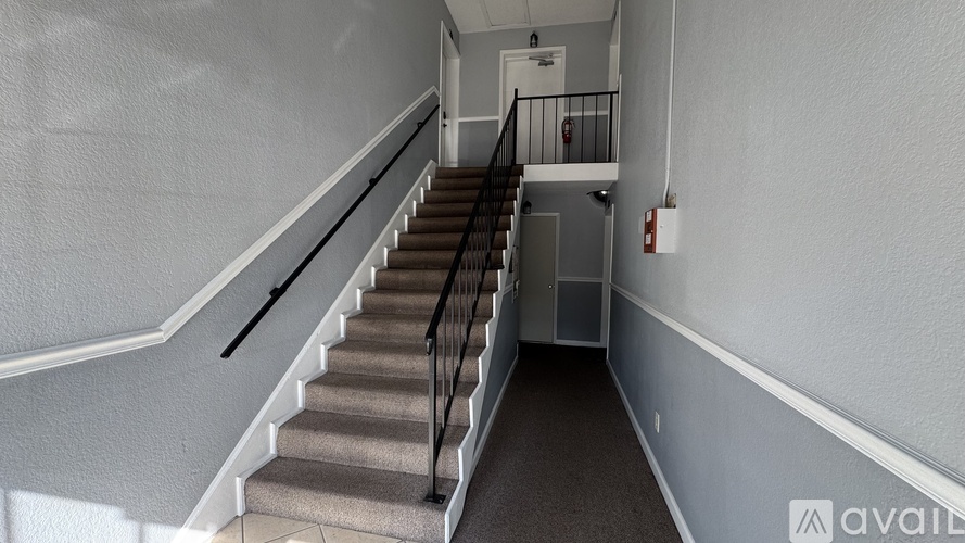 A staircase with a carpeted runner and a metal railing.