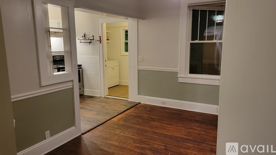 A room with a wooden floor and a white door.