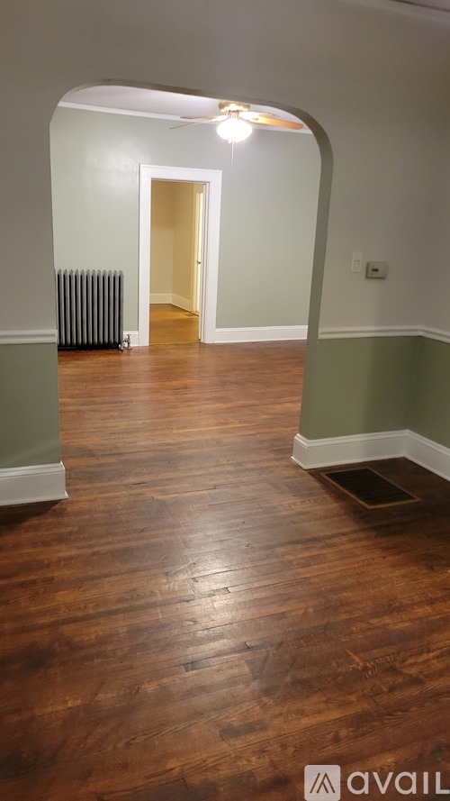 A hallway with wood floors and a light on.