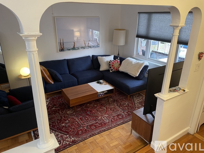 A living room with a dark blue couch and a wooden coffee table.