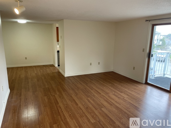 A room with wooden flooring and a sliding glass door.