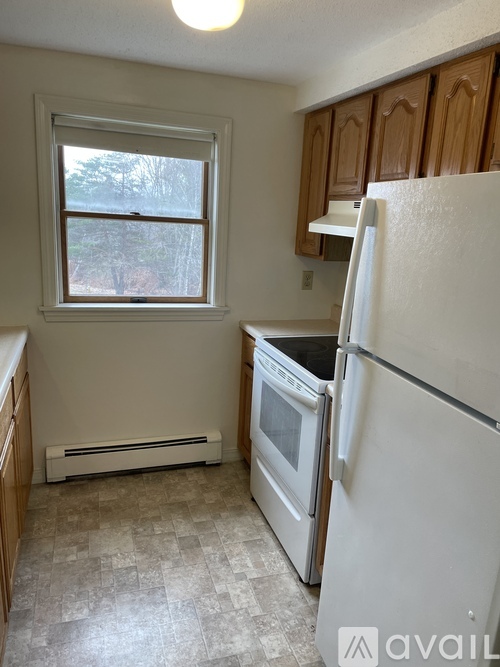 A kitchen with a white refrigerator and a window.